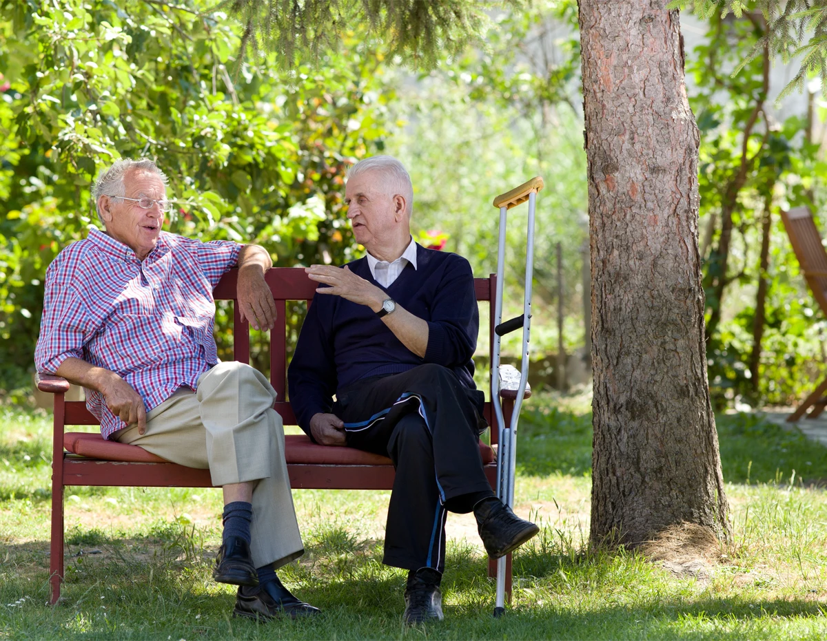 Two retired men sitting on bench in park